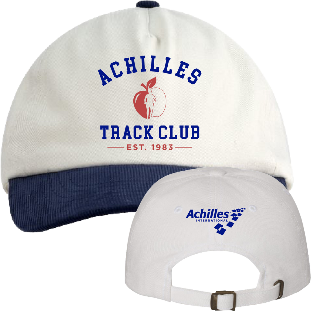 A cream baseball cap with a navy blue ribbed brim, featuring 'ACHILLES TRACK CLUB EST. 1983' and a red apple graphic on the front with a persons silhouette, with a smaller back view showing the adjustable strap and 'Achilles International' logo.